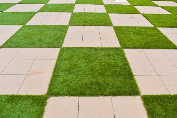 Real background of some tiles with grass in the form of a chessboard.