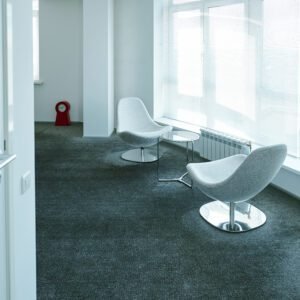 Two soft comfortable armchairs surrounding small round table by large window