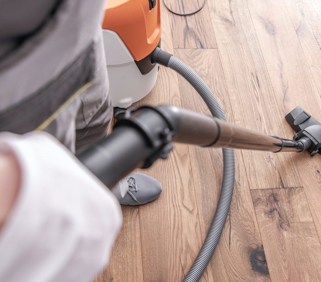 male-worker-vacuuming-hardwood-