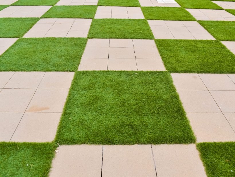 Real background of some tiles with grass in the form of a chessboard.